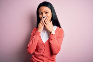 woman embarrassed by smile, covering up teeth